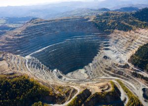 Flying above an open pit mine, copper excavation in Rosia Poieni, Romania. Aerial drone view